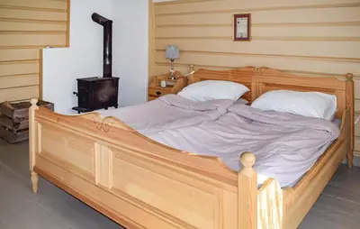 a large wooden bed in a room with aburning at Bakka in Bakka