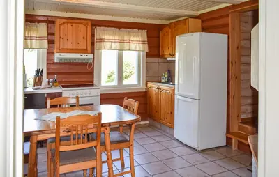 a kitchen with a table and a white refrigerator at Bakka in Bakka