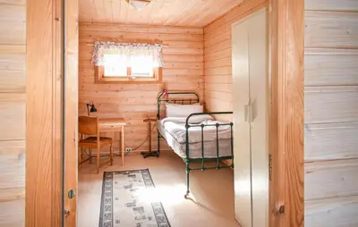 a small room with a bed in a wooden cabin at Bakka in Bakka