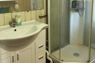 a bathroom with a sink and a glass shower at Cottage - Sleeps 6 - Parking - Patio in Ytteroy