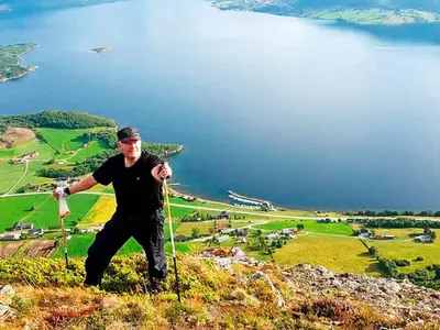 a man is standing on top of a mountain at 6 person holiday home in AVERØY in Stein
