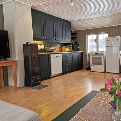 a kitchen with black cabinets and white appliances at Yttervik gard in Steinkjer