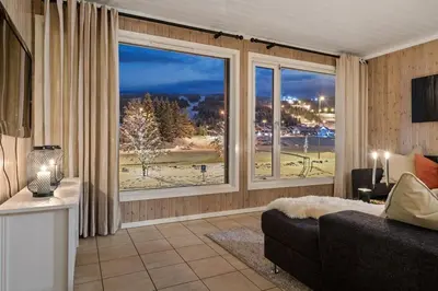 a living room with a couch and a large window at In the middle of Trysilfjellet - Welcome Center - Apartment with 3 bedrooms - By bike arena and ski lift in Trysil