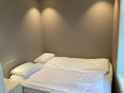 a bed with white sheets and pillows in a room at Skansen Apartments in Bergen