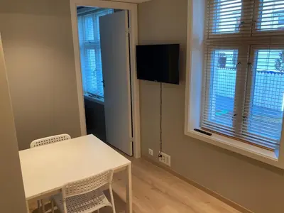 a small room with a table and chairs and a television at Skansen Apartments in Bergen