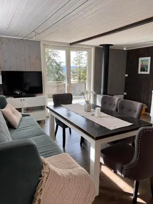 a living room with a table and a couch at Høgli på Yttervik gard in Fosnesstranden