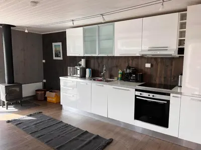 a kitchen with white cabinets and a stove top oven at Høgli på Yttervik gard in Fosnesstranden