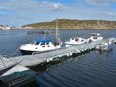 a group of boats docked at a dock in the water at 6 person holiday home in Kverva in Dyrvik