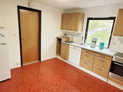 an empty kitchen with wooden cabinets and a window at 9 person holiday home in KORTGARDEN in Skalle