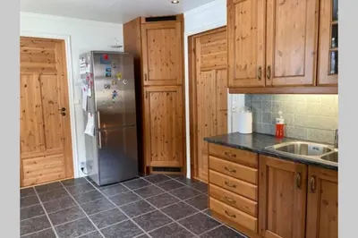 a kitchen with wooden cabinets and a stainless steel refrigerator at Comfortable house in quiet area in Luster