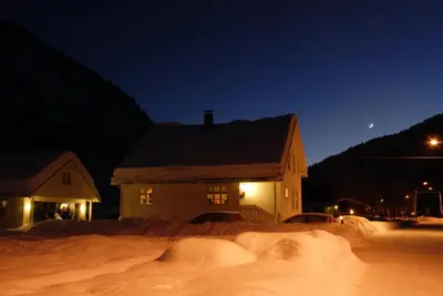 a house is covered in snow at night at Comfortable house in quiet area in Luster