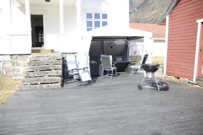 a patio with chairs and a grill and an umbrella at Comfortable house in quiet area in Luster