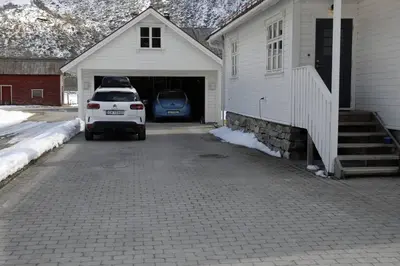 a car parked in a garage next to a house at Comfortable house in quiet area in Luster