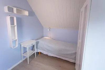 a small bedroom with a bed and a table at Raaehuset in Lavik
