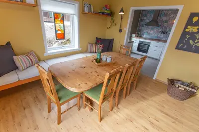 a dining room with a wooden table and chairs at Raaehuset in Lavik