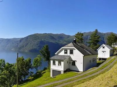two white houses on a hill with a body of water at 10 person holiday home in Stordal in Stordal
