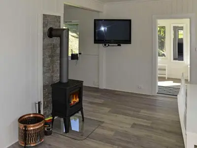 a living room with a stove and a tv at 10 person holiday home in Stordal in Stordal