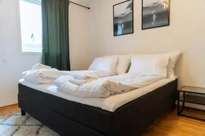 a bed with white sheets and pillows on it at Stryn Apartments - City Center - Modern Suites in Stryn