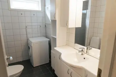 a white bathroom with a sink and a toilet at Stryn Apartments - City Center - Modern Suites in Stryn