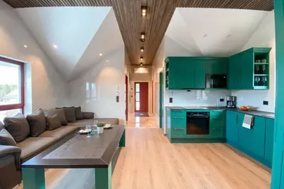 a living room with green cabinets and a couch at Flatanger Turkish Bath apartment in Lauvsnes