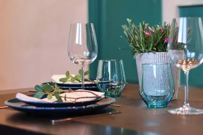 a wooden table with glasses and plates of food on it at Flatanger Turkish Bath apartment in Lauvsnes