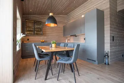 a kitchen with a wooden table and blue chairs at Panorama 13 - beautiful view! in Sogndal