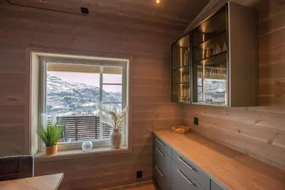 a kitchen with wooden walls and a window and a counter at Panorama 13 - beautiful view! in Sogndal