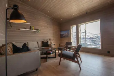 a living room with a couch and a table at Panorama 13 - beautiful view! in Sogndal