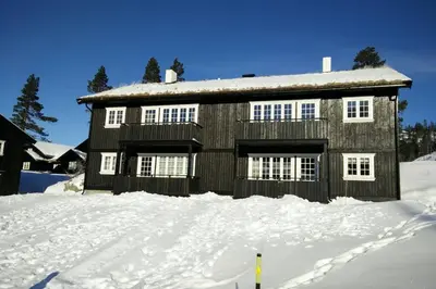 a house with snow on the ground in front of it at Apartment Gaustablikk in Gaustablikk