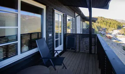 a balcony with a chair and a view of a mountain at Hodlekve Panorama 5 - amazing view in Sogndal