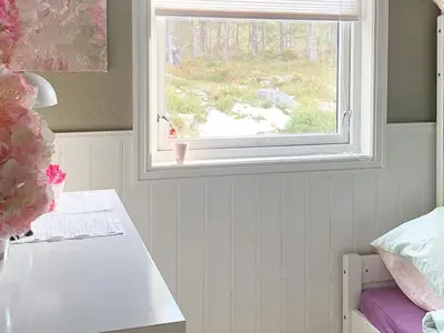 a bedroom with a window and a table with a vase at 6 person holiday home in Aure-By Traum in Aure