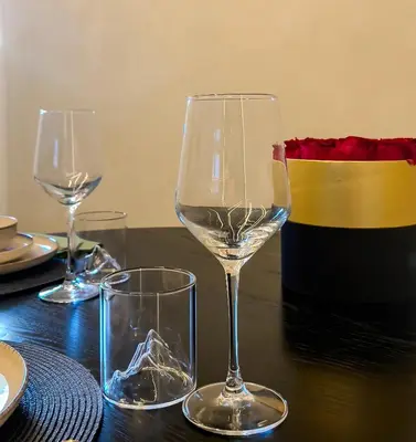 three wine glasses sitting on top of a wooden table at ÅNDALSNES UNDERGROUND flat in Åndalsnes