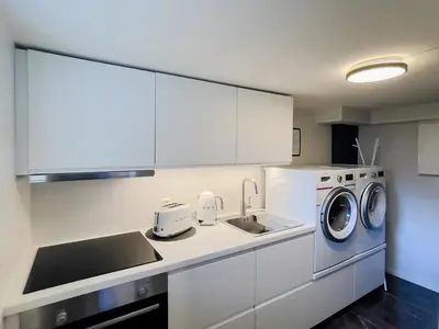 a kitchen with a washing machine and a sink at ÅNDALSNES UNDERGROUND flat in Åndalsnes