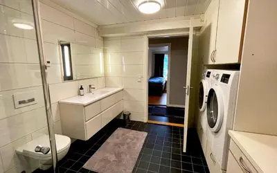 a bathroom with a sink and a washing machine at Otnes Fjordside - Large 80m2 860sqft in Aurland
