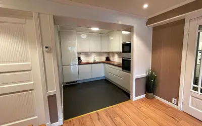 a kitchen with white cabinets and a black floor at Otnes Fjordside - Large 80m2 860sqft in Aurland