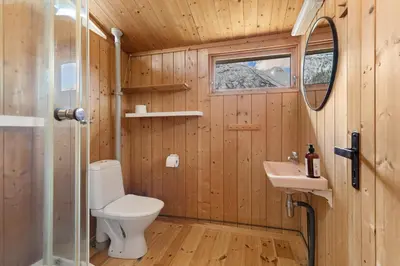a bathroom with a toilet and a sink at Lem Cabins in Sogndal