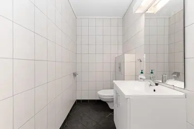 a white bathroom with a toilet and a sink at Lem Cabins in Sogndal