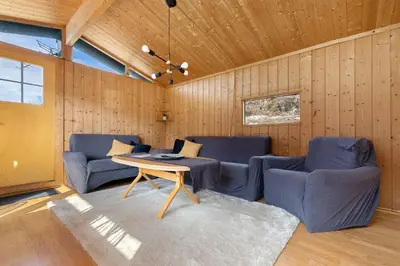 a living room with blue chairs and a table at Lem Cabins in Sogndal