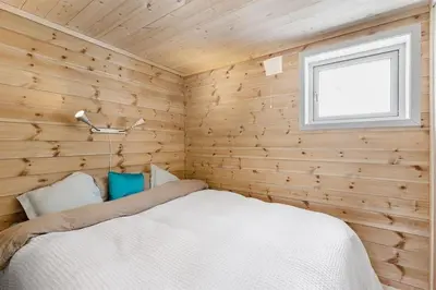 a bedroom with a bed in a wooden wall at Tiny mountain cabin with a panoramic view in Giljane