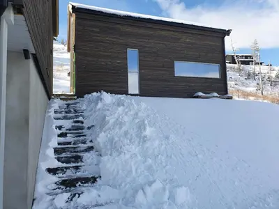 a pile of snow in front of a house at Tiny mountain cabin with a panoramic view in Giljane