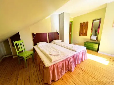 a bedroom with a large bed and a green chair at Tiglkåk in Åndalsnes