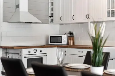 a kitchen with a table with chairs and a microwave at Cabin in Trysil with seaview to lake in Trysil