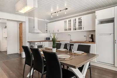 a kitchen and dining room with a wooden table and chairs at Cabin in Trysil with seaview to lake in Trysil