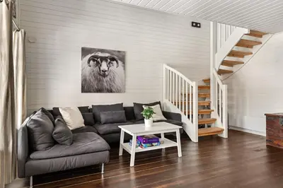 a living room with a couch and a picture of a cow at Cabin in Trysil with seaview to lake in Trysil