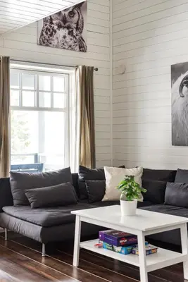 a living room with a black couch and a white coffee table at Cabin in Trysil with seaview to lake in Trysil