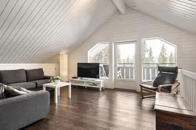 a living room with a couch and a tv at Cabin in Trysil with seaview to lake in Trysil