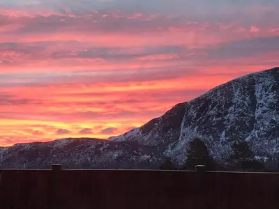 a sunset over a mountain in front of a fence at Private apartments!Oppdal Alpintun, Skisenter-Stølen in Oppdal