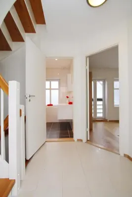 an open living room with white walls and a staircase at Villa Skansen in Bergen