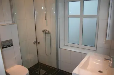 a bathroom with a shower and a toilet and a sink at Villa Skansen in Bergen