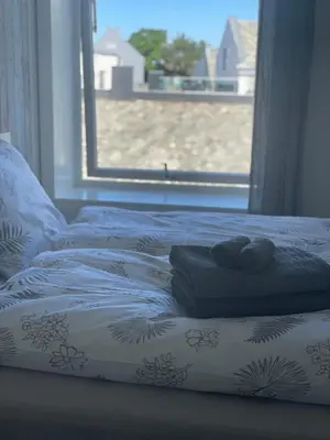 a bed with two towels on it with a window at City Center Apartment in Ålesund
